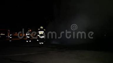 消防队员在夜间扑灭燃烧的汽车